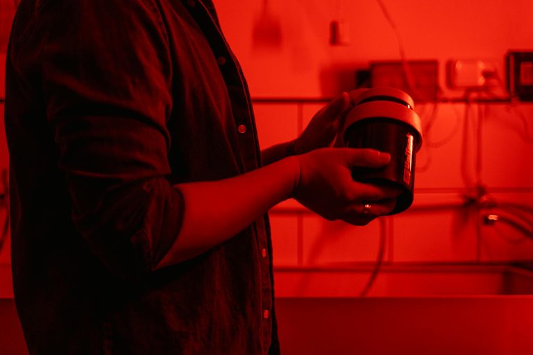Person in Brown Button Up Shirt Holding Black and White Disposable Cup
